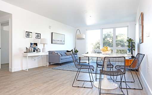 A living room with a grey couch and a white coffee table.