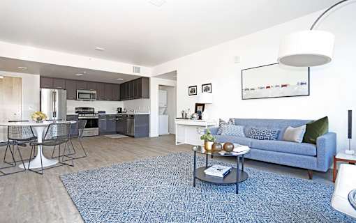 A modern living room with a blue couch and a coffee table.