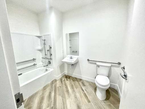 A white bathroom with a toilet, sink, and bathtub.