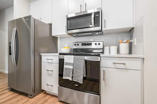 a kitchen with white cabinets and stainless steel appliances