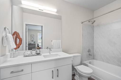 a bathroom with a white sink and toilet next to a white bathtub with a shower curtain