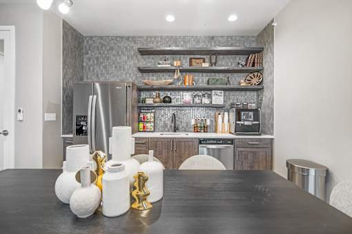 a kitchen with a large black table and stainless steel appliances