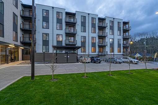 an exterior view of an apartment building at dusk