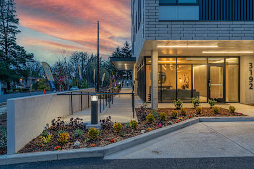 a view of the front entrance of a building with a sunset in the background