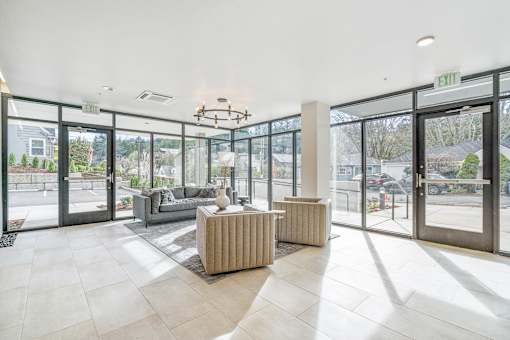 a living room with a couch and a coffee table in front of a wall of glass doors
