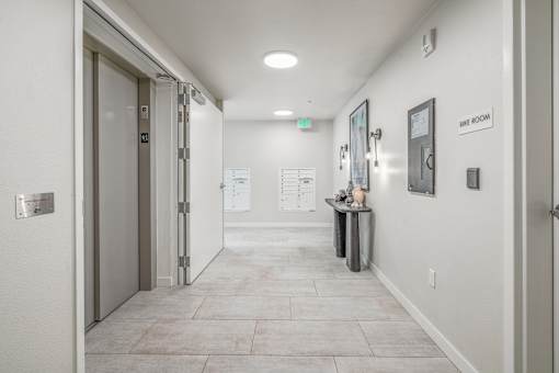 a hallway with a door at the end and a counter on the side of the hallway
