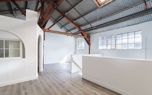 A large, empty room with wooden floors and white walls.