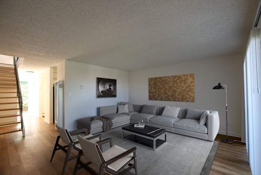 Living room setting with coffee table, couch and chairs at Villas at Harbor Pointe