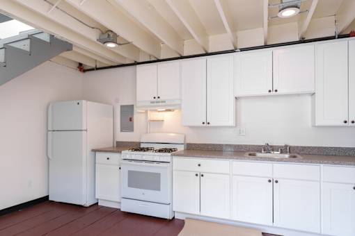 A kitchen with white cabinets and appliances.