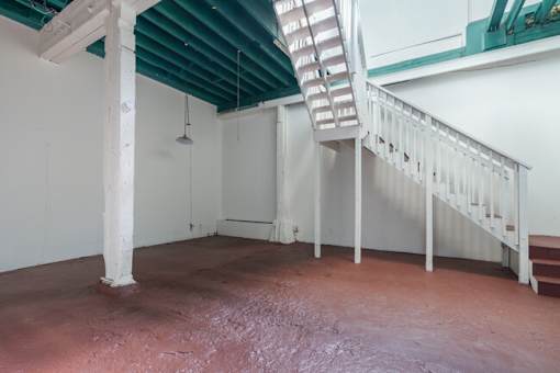A room with a white staircase and a green roof.