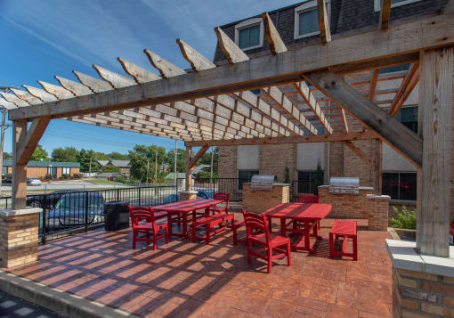 a patio with a table and chairs under a wooden roof