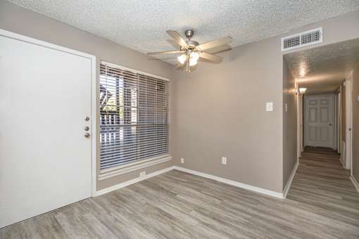 A room with a ceiling fan and a door.