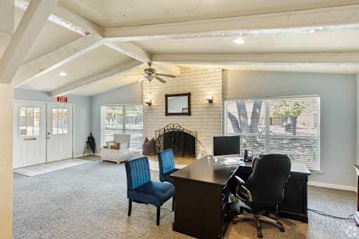 a leasing office with a desk and chairs and a fireplace