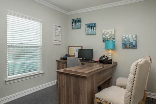 a office with a desk and a chair and a window