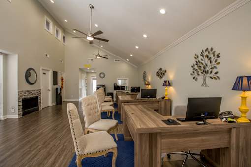 a home office and living room with a desk and chairs and a fireplace