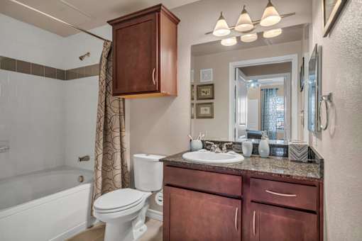 A bathroom with a white toilet and a white bathtub.