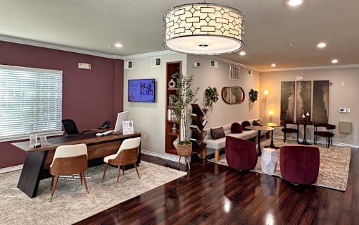 A modern living room with a dark wood floor and a large chandelier.