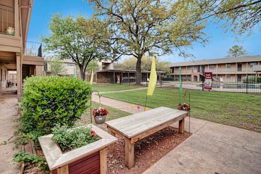 A wooden bench sits in the middle of a garden.