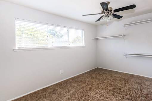 a bedroom with a ceiling fan and a window