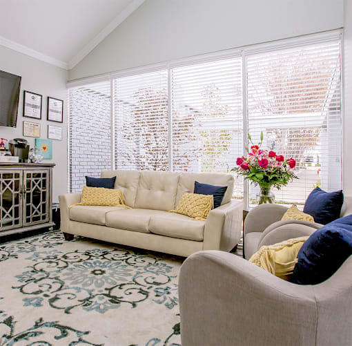 a living room with a couch and chairs and a large window