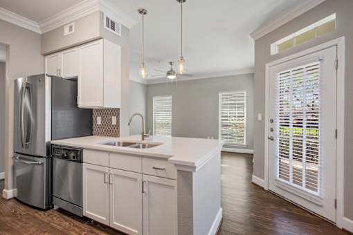a kitchen with white cabinets and a stainless steel refrigerator