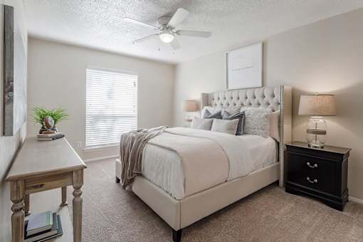 a bedroom with a bed and a ceiling fan