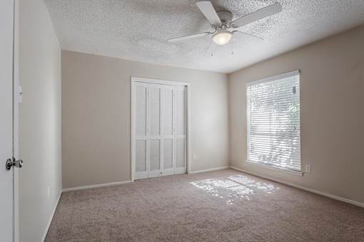 a bedroom with a ceiling fan and a window
