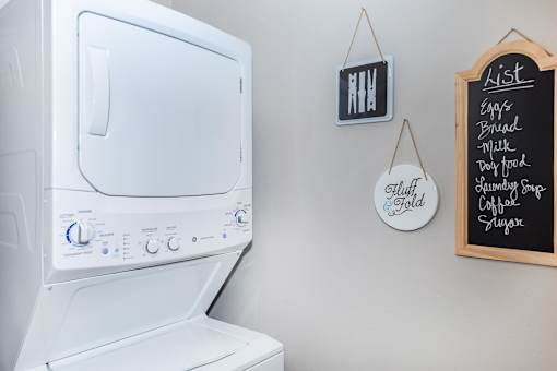 the laundry room has a large washer and dryer and a wall mounted tv