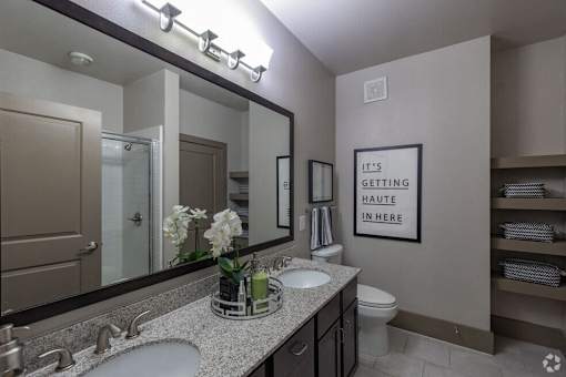a bathroom with two sinks and a large mirror