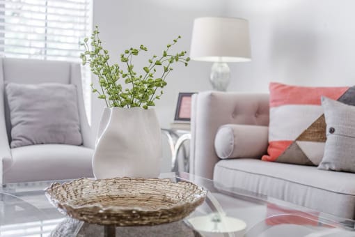 a living room with white furniture and a glass table