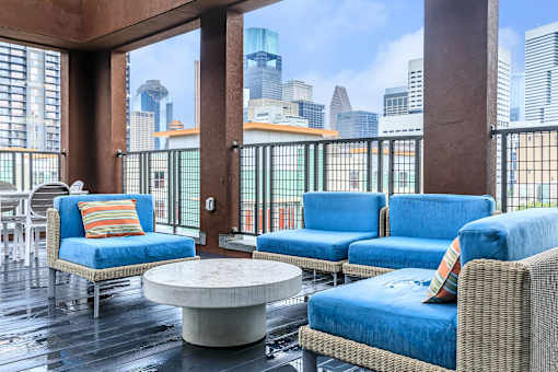 a lounge area with blue chairs and a view of the city