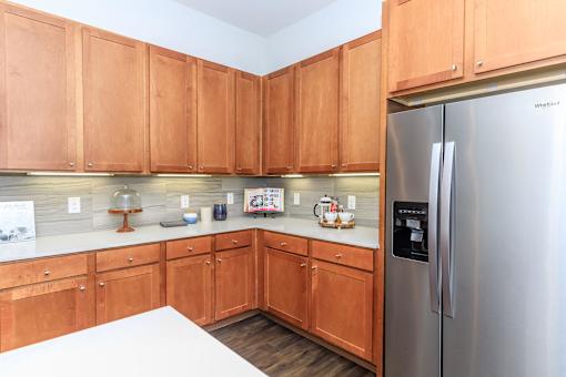 a kitchen with wooden cabinets and a stainless steel refrigerator