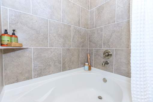 a bathroom with a bath tub and tiled walls