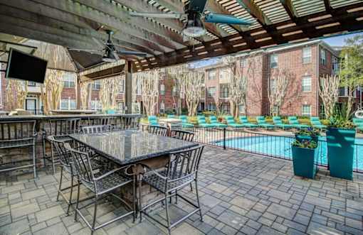 a patio with a table and chairs next to a swimming pool