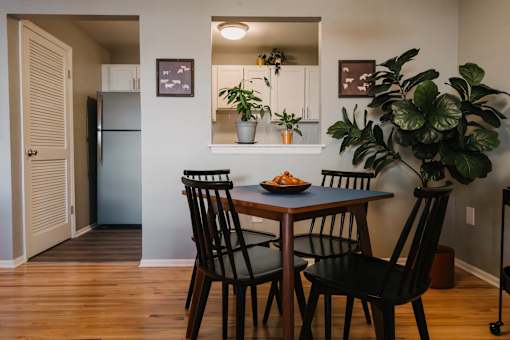 a dining room with a table and chairs and a refrigerator