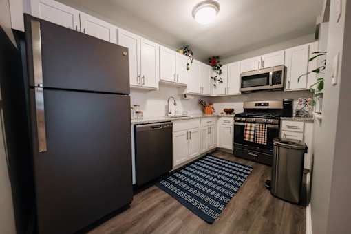 a kitchen with white cabinets and black appliances and a black refrigerator