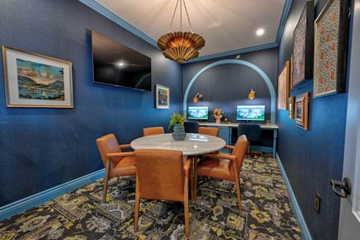 A dining room with a round table and chairs.