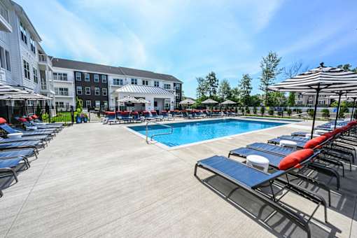 A sunny day at the pool with lounge chairs and umbrellas.