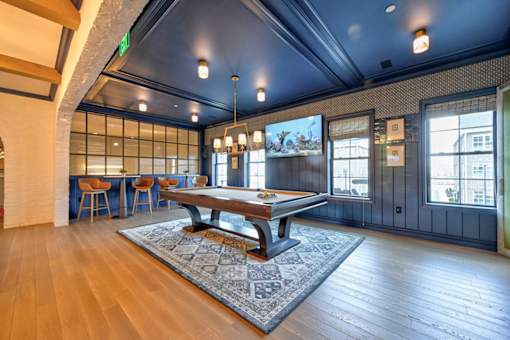 A room with a long table and chairs with a view of the outside.