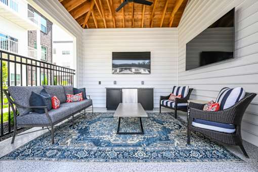 A patio with a couch, chairs, and a coffee table.