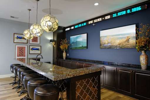 A bar with a row of stools and a counter with a patterned design.