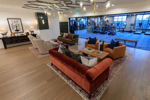A living room with a red couch and a wooden floor.