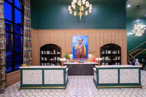 A room with a green wall and a painting of a person on the wall.
