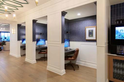 A room with a row of computers on desks.