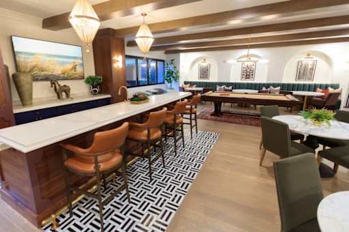 A modern dining room with a long table and chairs.