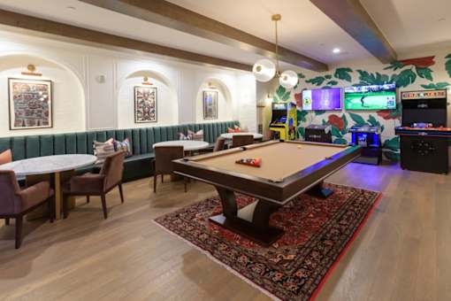 A room with a pool table and a dartboard.