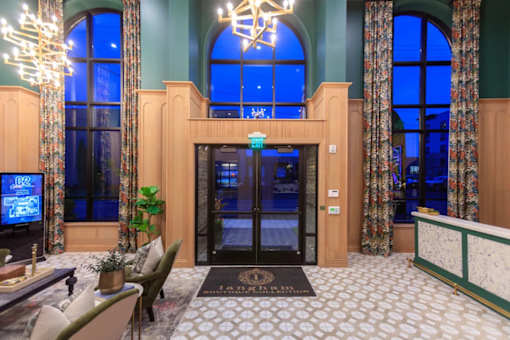 A hotel lobby with a large screen TV and a reception desk.