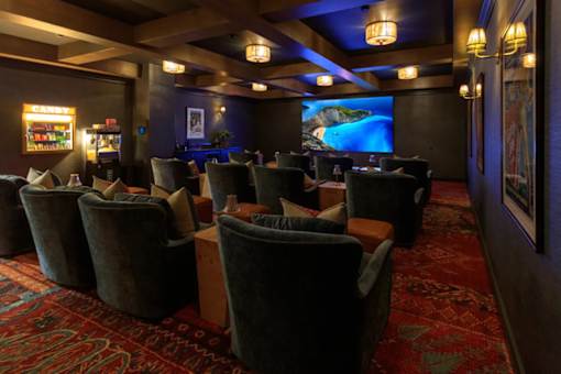 A room with a red carpet and a large screen on the wall.
