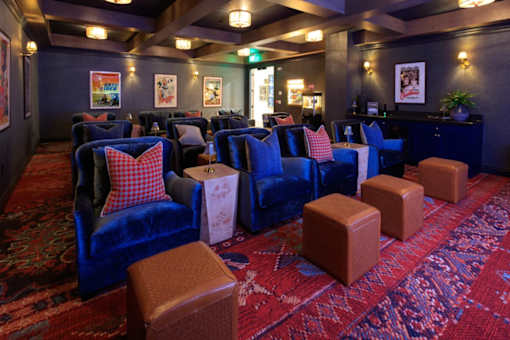 A room with blue chairs and red carpet.