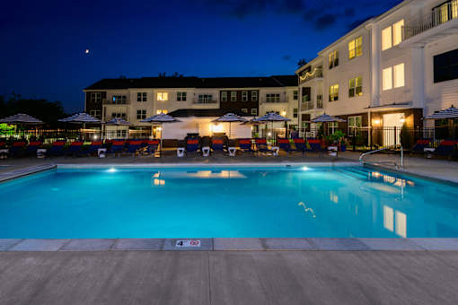 A swimming pool at a resort with a building in the background.